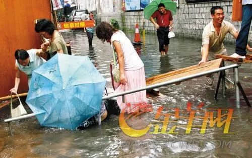 2009年，崗頂。雨后，有人在三輪車主搭好的橋上行走，忽然橋斷，濕了一身 / 圖自金羊網(wǎng)