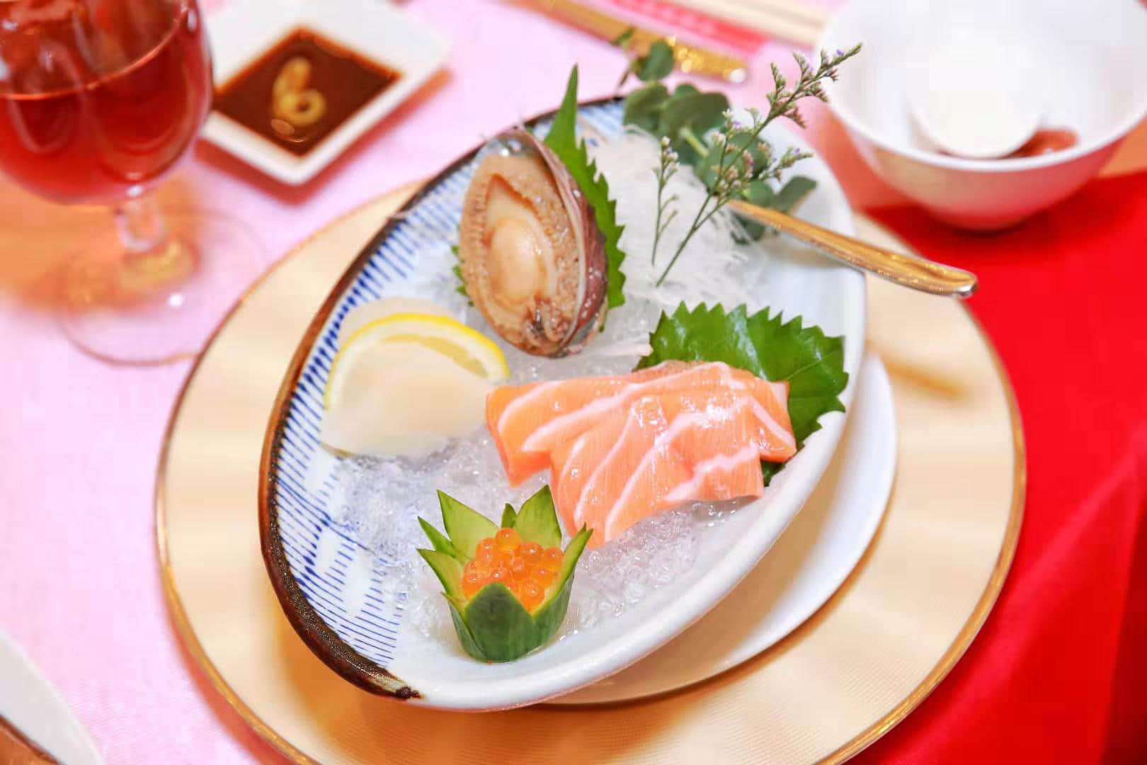 冰鎮(zhèn)鮑魚三文魚：選取大連鮑、挪威三文魚、加拿大帶子，這是三大海產(chǎn)品完美組合，每一口都充滿海洋風(fēng)味，大口嘗鮮不能停。鮑魚肉質(zhì)豐滿，原汁原味；肥美三文魚，廚師手起刀落，肉身肥厚；帶子的鮮味層次更加豐富。