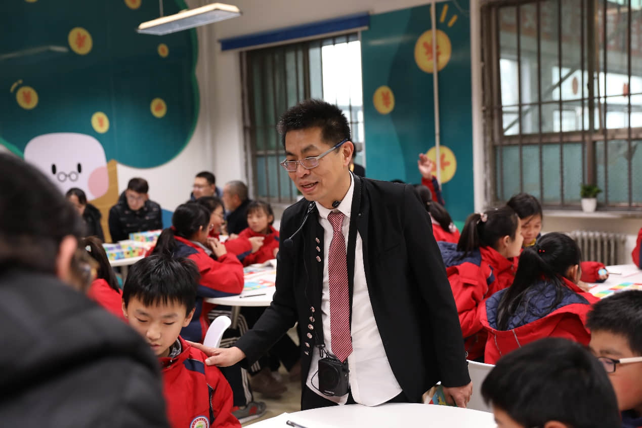 D:\Users\Desktop\【青少年財經(jīng)素養(yǎng)實踐中心】項目\稿件照片\隨手記&九果教育:財商啟蒙課\陳圣雄指導(dǎo)學(xué)生玩財商游戲.JPG
