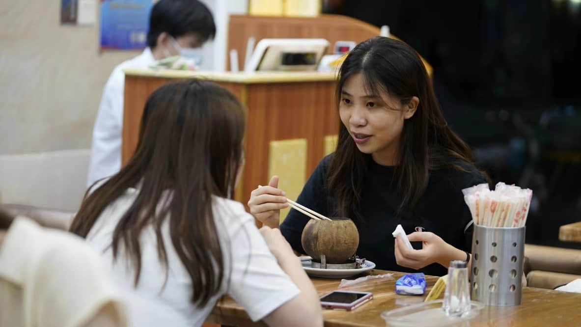 ▲消費者在廣州必吃榜餐廳“達揚原味燉品”品嘗“原只椰子燉竹絲雞”,攝影:蘆葦