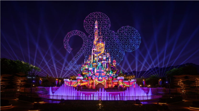 A castle with lights and a fountain

Description automatically generated