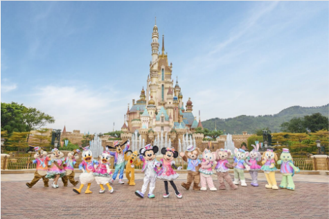 A group of people in clothing in front of a castle with Disneyland Paris in the background

Description automatically generated