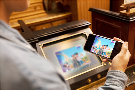 A person holding a phone and looking at a picture

Description automatically generated